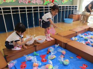 幼児が手作りの魚を釣っている