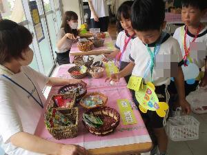 幼児がお菓子屋で予算を踏まえてお菓子を選んでいる