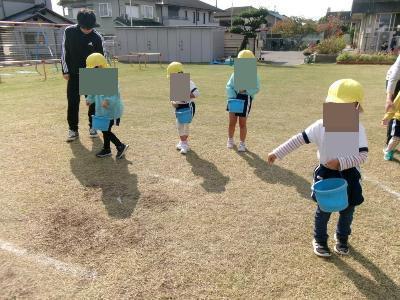 芝生の種をまく4歳児