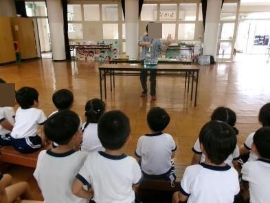 水の実験を見る幼児