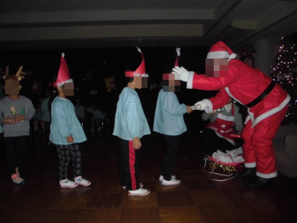 サンタからプレゼントをもらうこども達