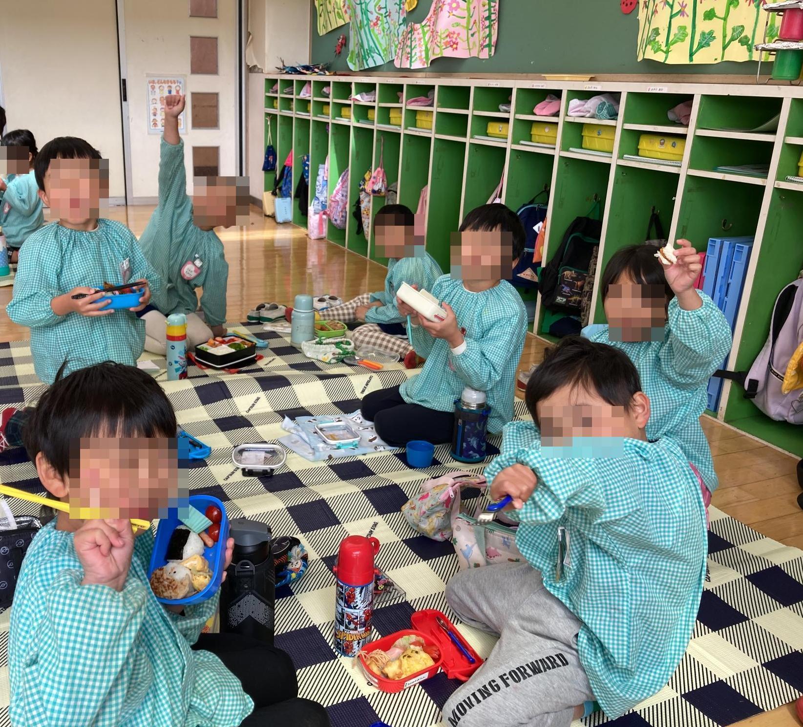 シートを敷いてお弁当を食べる幼児達