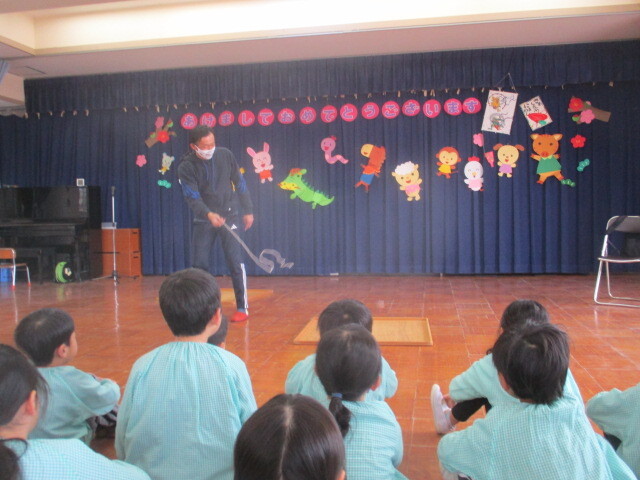 駒回し名人の技を見る幼児の姿