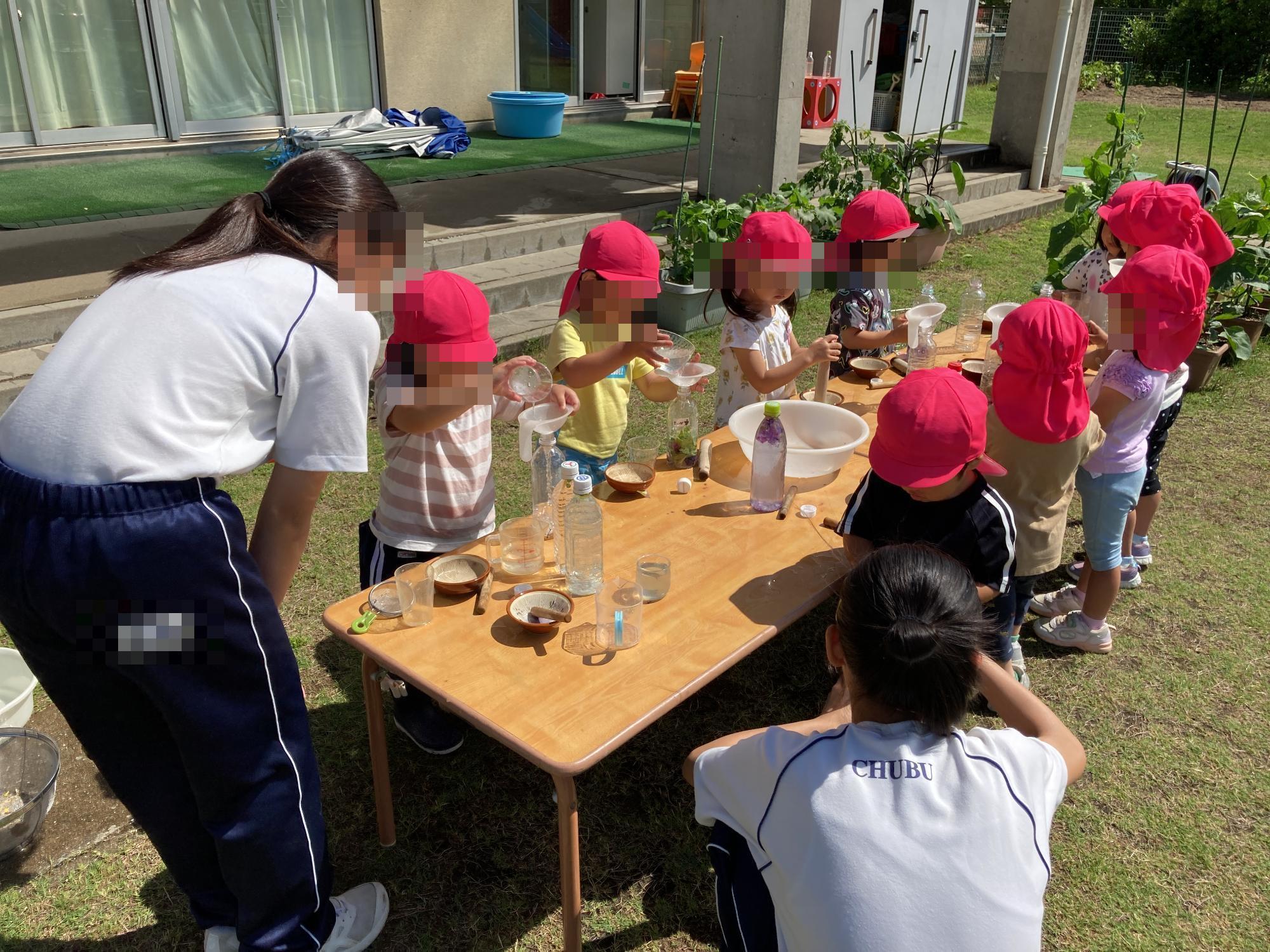 中学生と一緒に色水遊びをする幼児