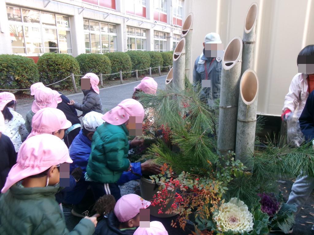 門松づくりで土を入れている幼児達