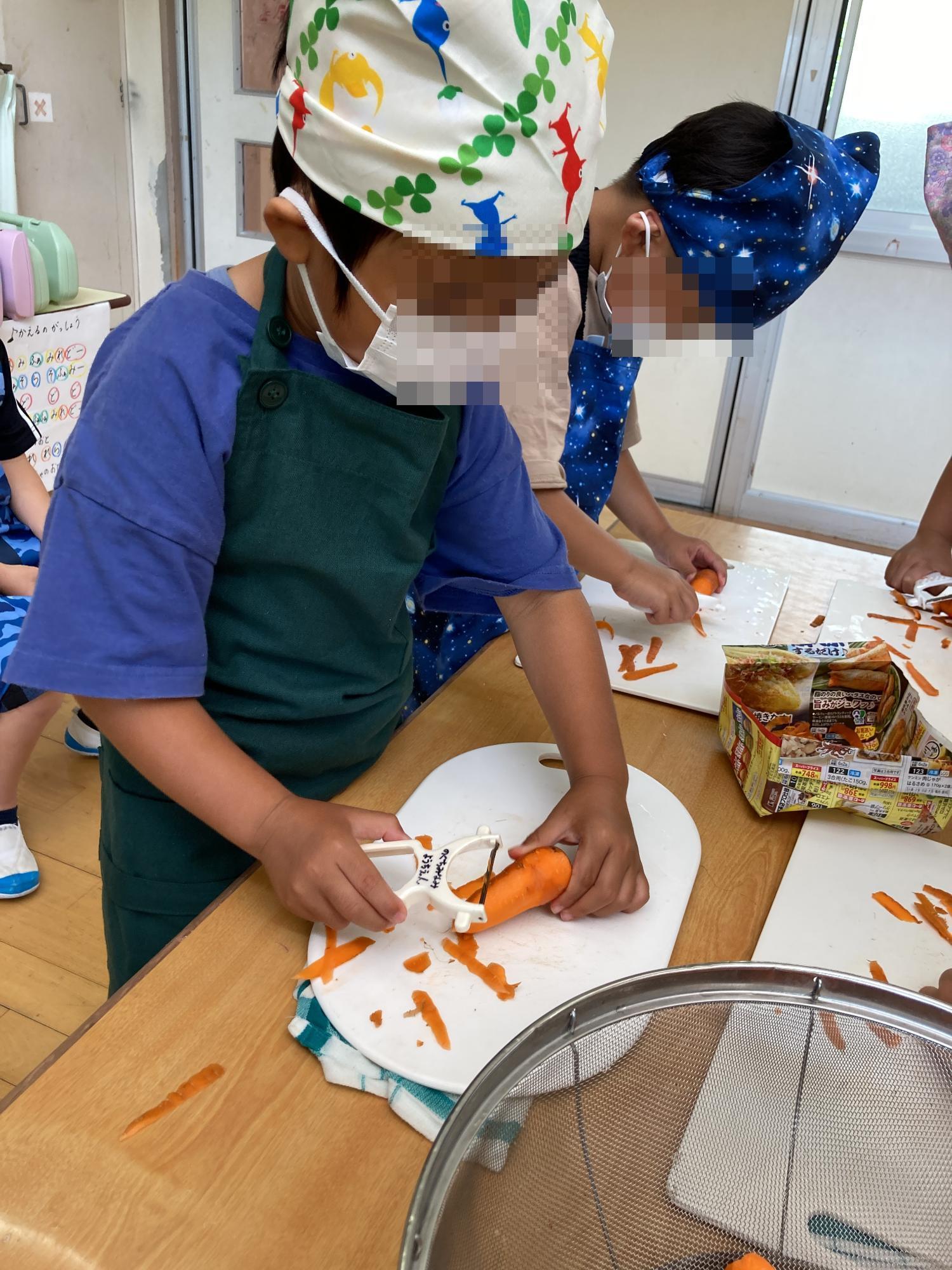 ニンジンの皮をむく5歳児