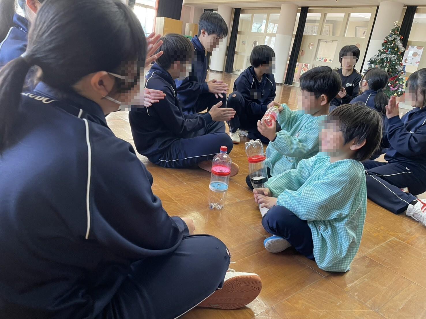 手作りおもちゃで遊ぶ中学生と幼児