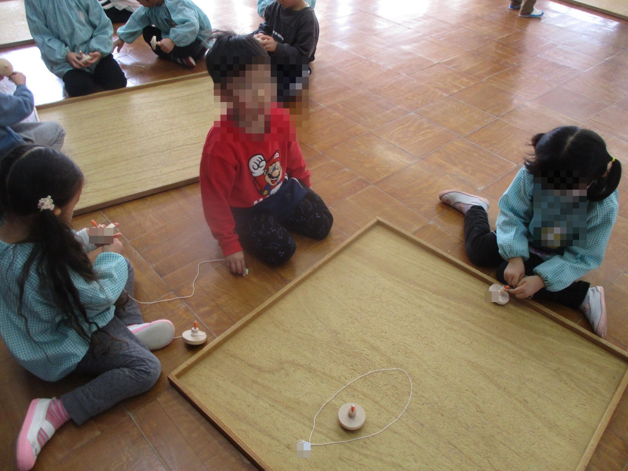 駒回しに挑戦する幼児