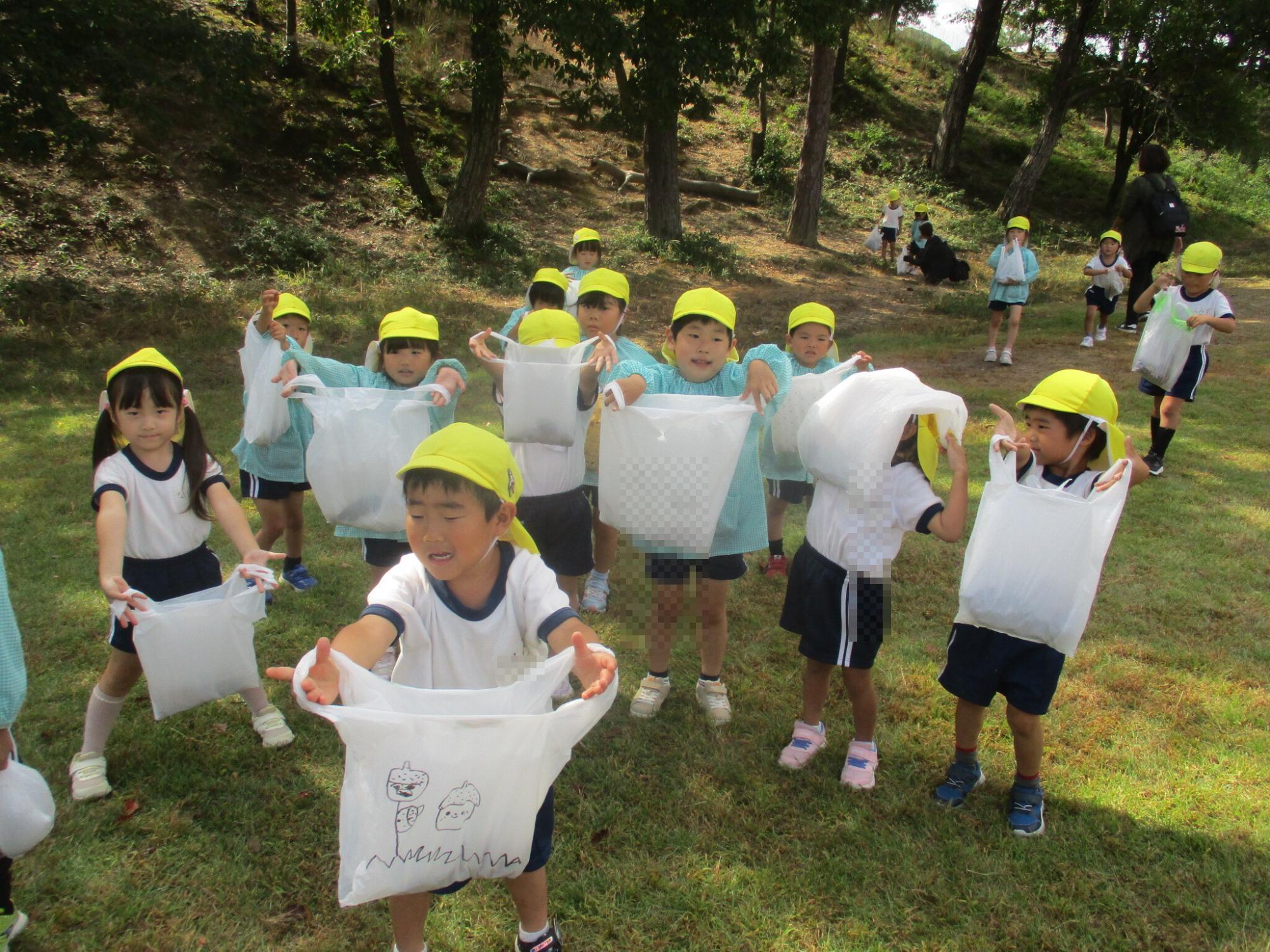 見つけたどんぐりを袋に入れて喜んでいる様子