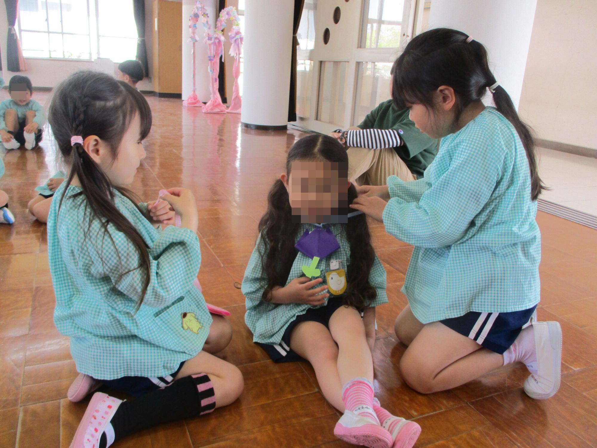 4歳児にメダルをかける5歳児