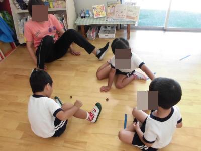 どんぐりで遊ぶ園児