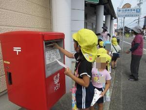 ポストに手紙を投函しているところ