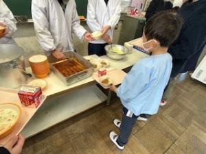 給食をよそってもらっているところ