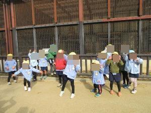 ライオンの檻の前でライオンのポーズをしているところ