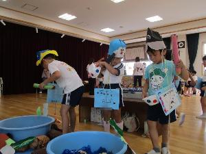 遊戯室で折り紙の釣りを楽しんでいる幼児