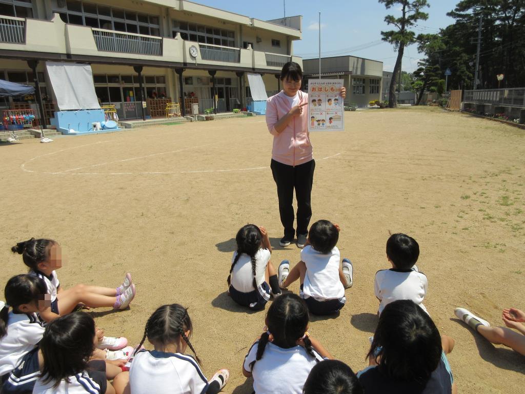 園庭に避難後に教師の話を聞く園児たち