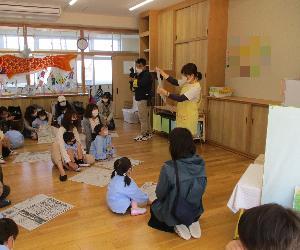 お家の方と新聞紙で兜を折っている写真です。
