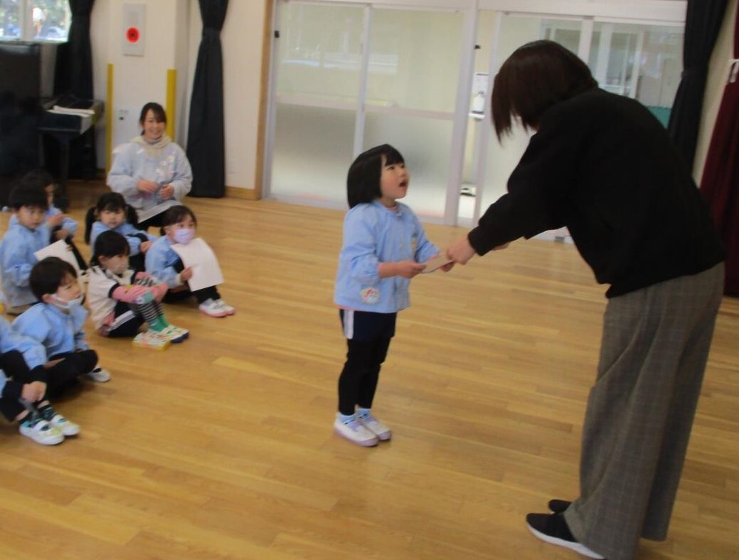 かるた大会でたくさんかるたを取り、園長先生に表彰されている様子。