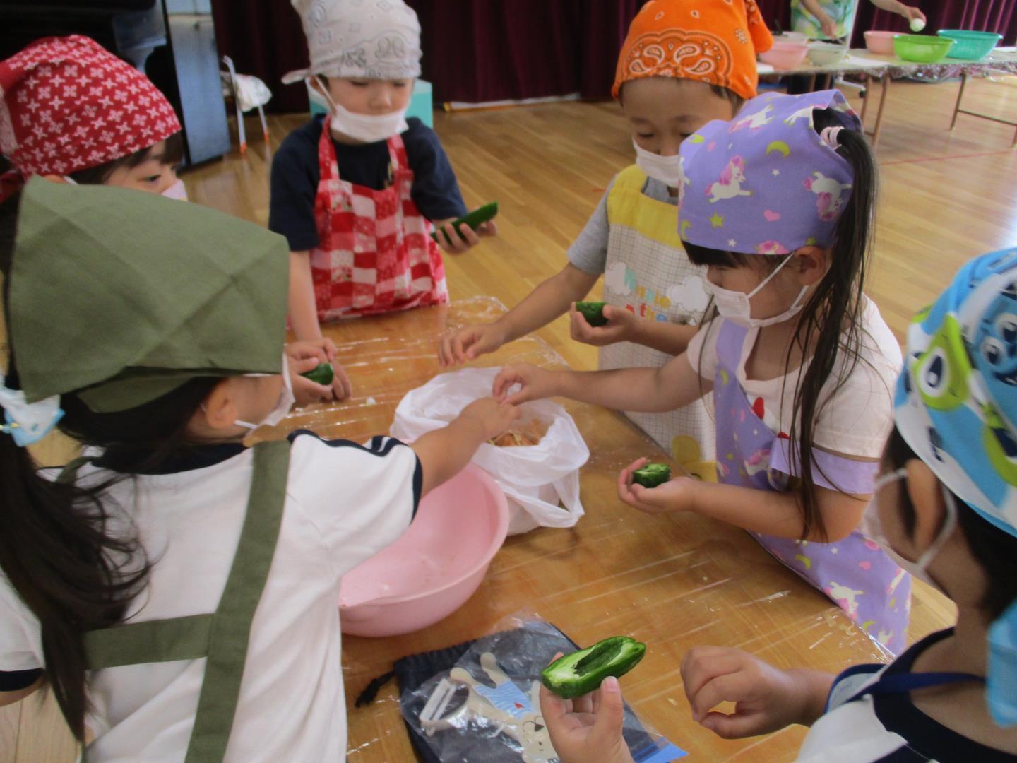子ども達がピーマンの種取りをしている様子。