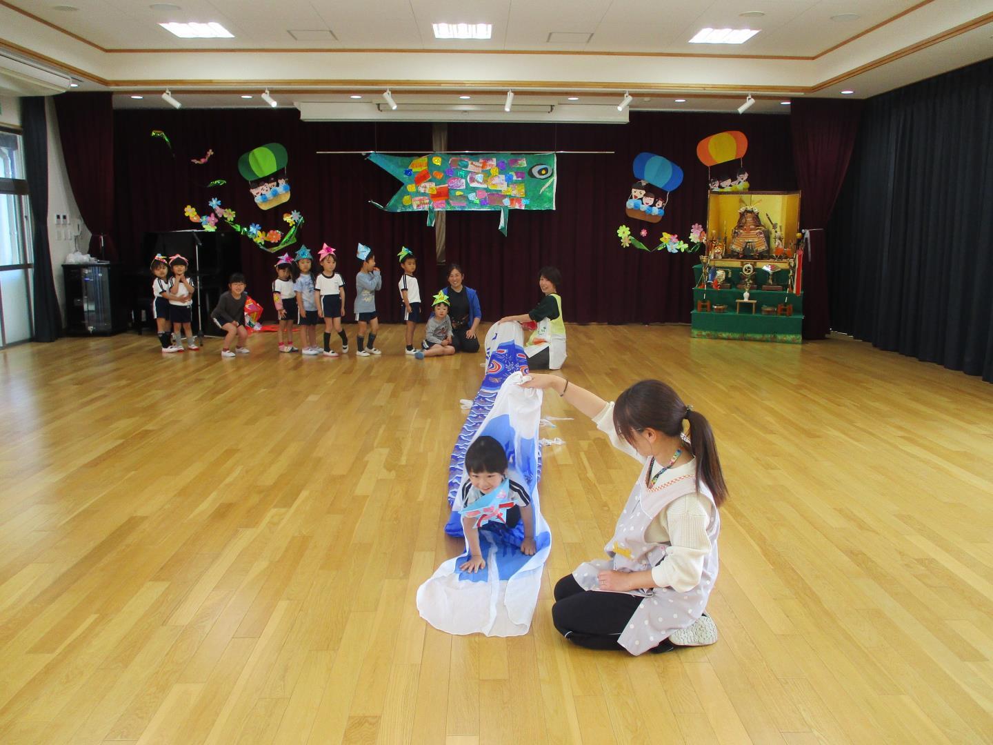 こいのぼりの中を通り抜けて遊んでいる様子。
