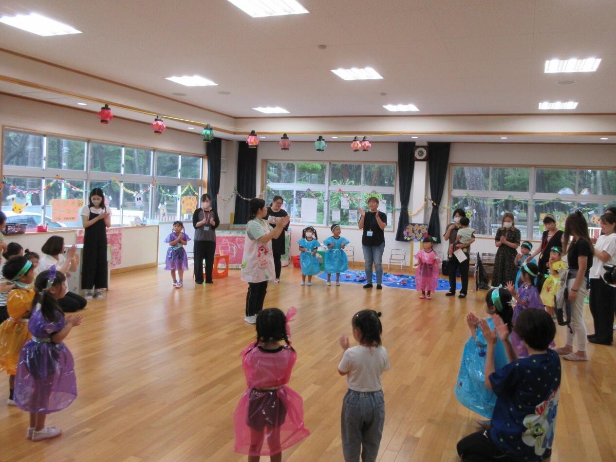 幼稚園児、未就園児、お手伝いのおうちの方で盆踊りを踊っているところ。