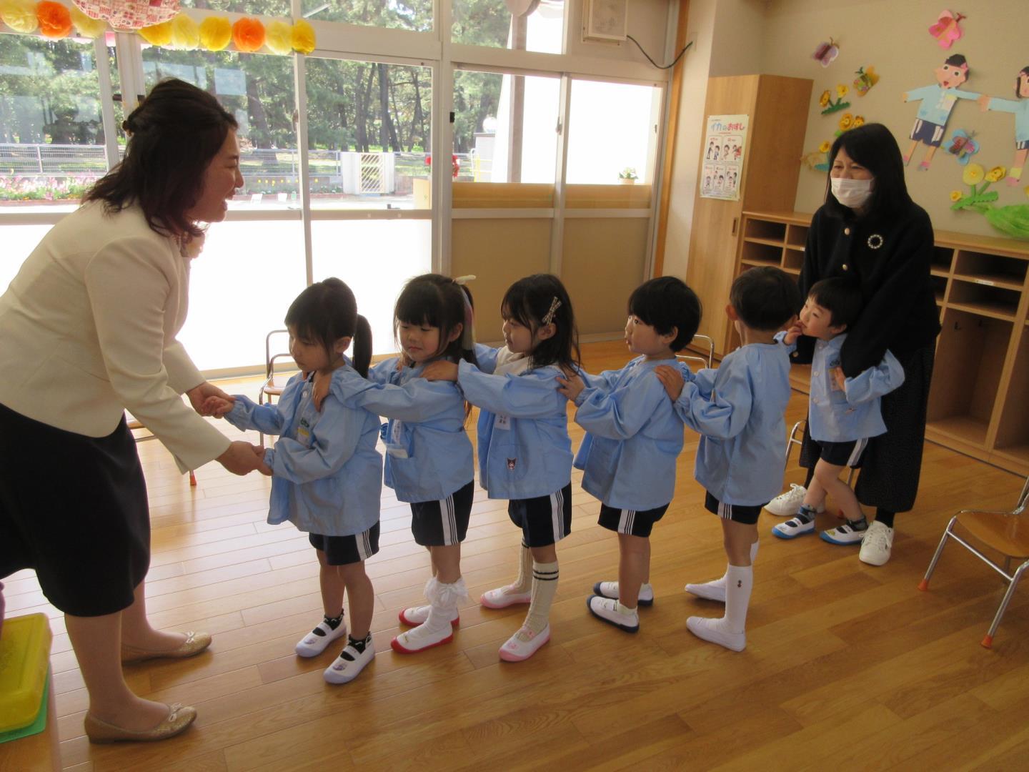 4歳児が初めての幼稚園で先生と一緒に入園式へ向かう様子。
