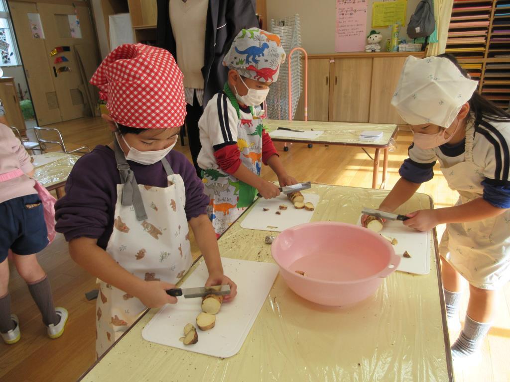 こどもたちがサツマイモを包丁で切っている様子
