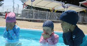 どきどきしながらプールの水で顔を洗う年少児