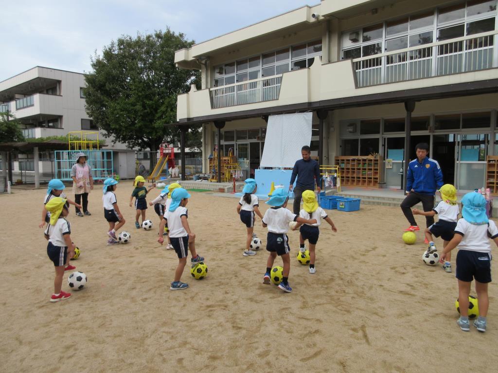 サッカー教室のコーチに来てもらい、パスやドリブルをして遊んでいる様子。