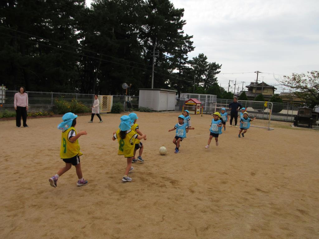 2チームに分かれて、サッカーの試合をしている様子。