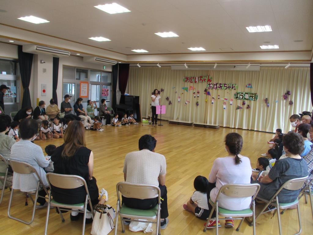 子供たちと祖父母の方が集まって話を聞いているところ