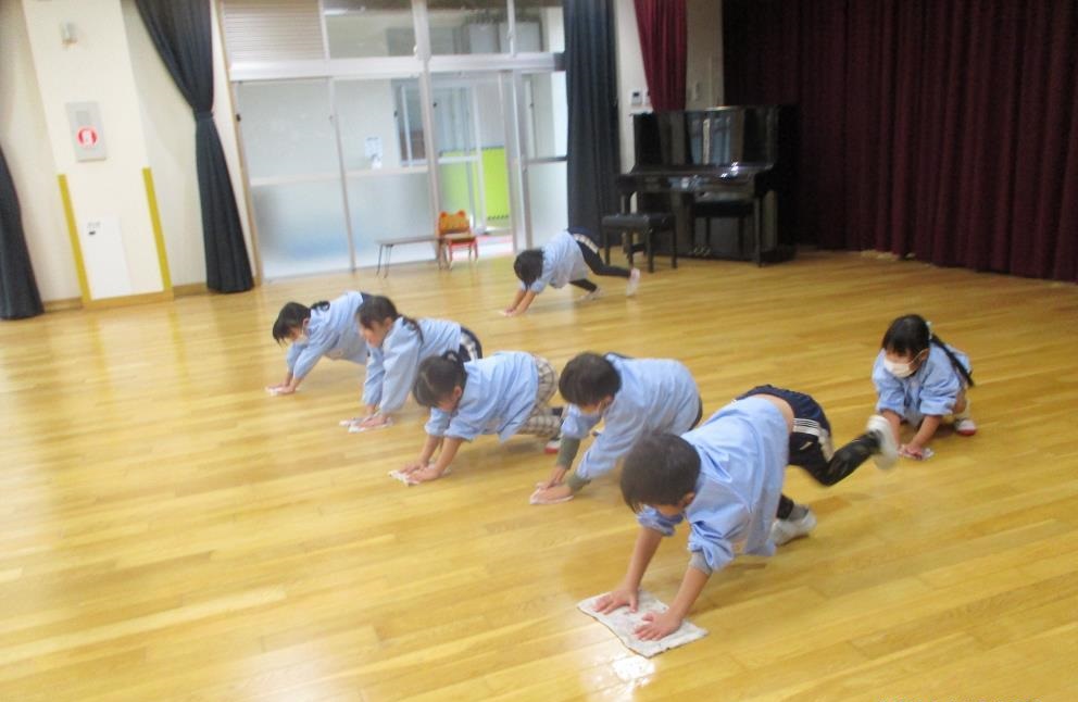 みんなで遊戯室の床を雑巾がけしている様子
