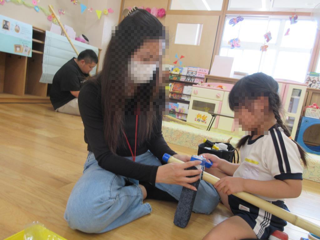 園児と保護者が竹馬を作る様子