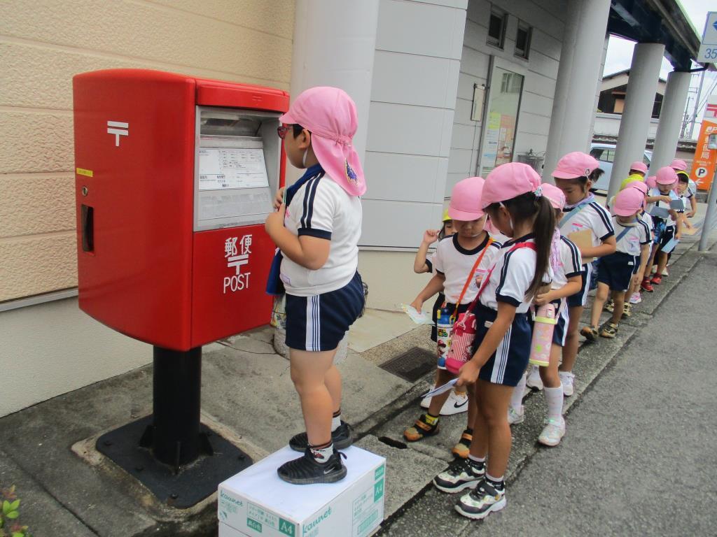 郵便ポストに手紙を投函しているところ