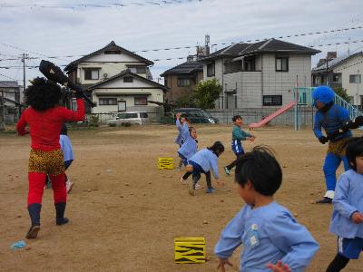 幼稚園に赤鬼と青鬼がやってきて、豆をまいてやっつける様子