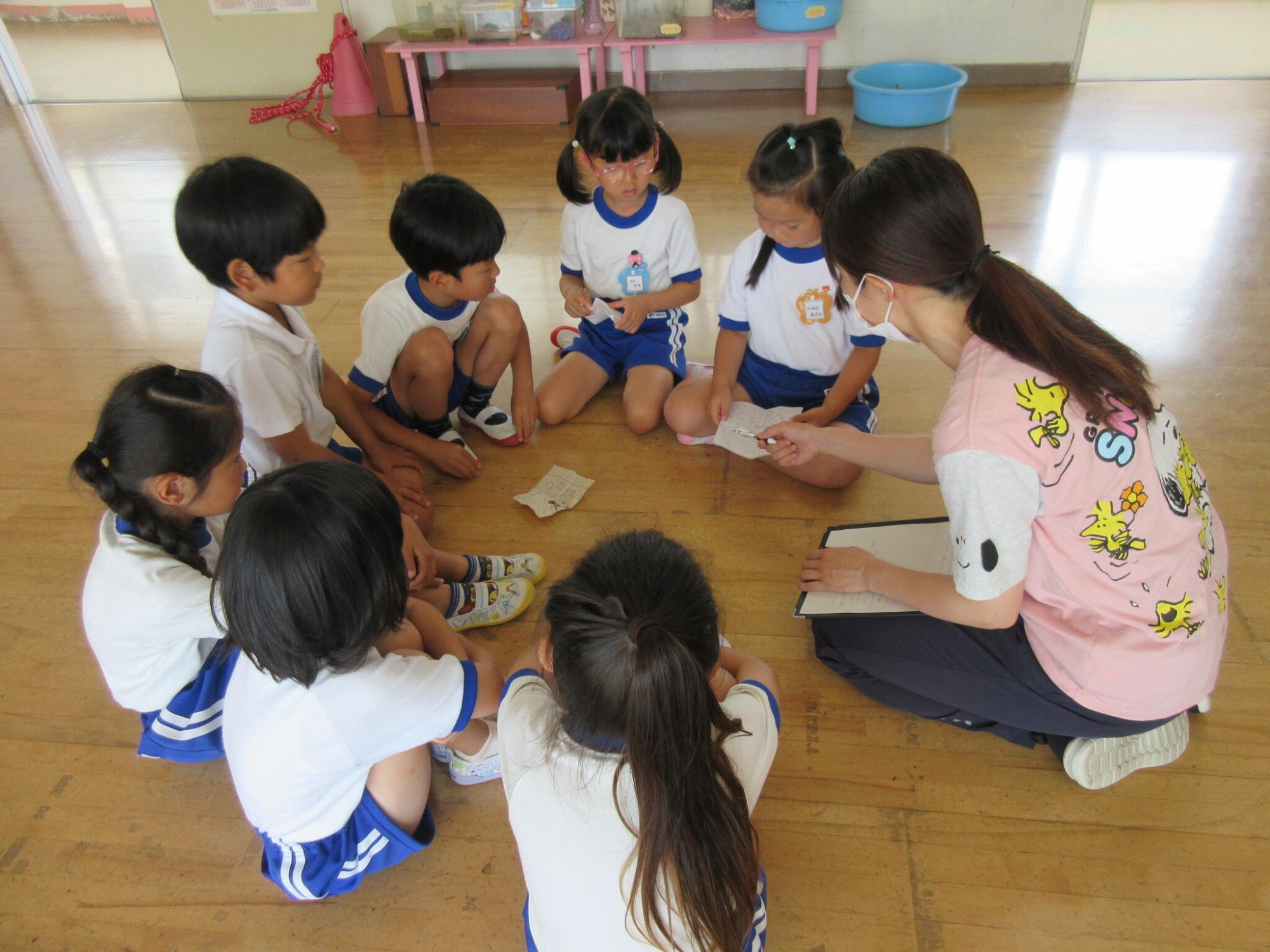 夏祭りの出し物について、先生と友達で話し合う様子