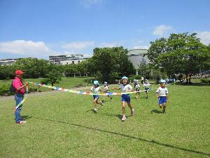 芝生でかけっこする子供たち