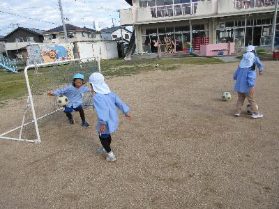 園児がサッカーをする様子