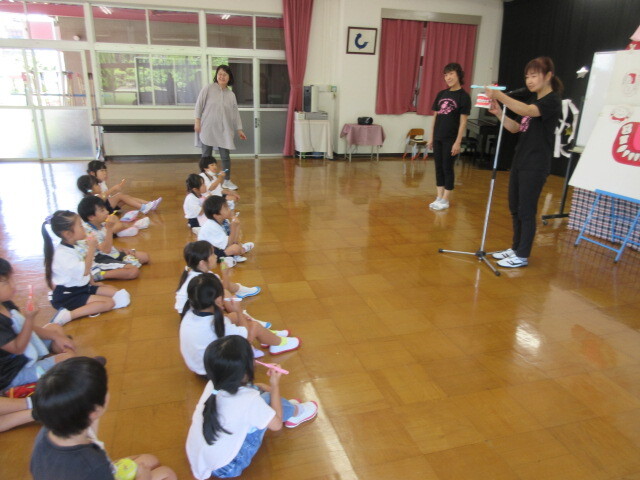 幼児が歯磨きの仕方を教えてもらっている様子