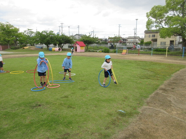 幼児がフラフープをして遊んでいる様子