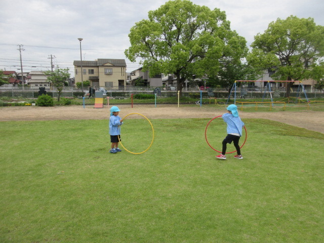 幼児がフラフープを転がしている様子