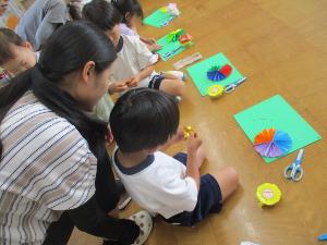 幼児が扇飾りを作っているところ