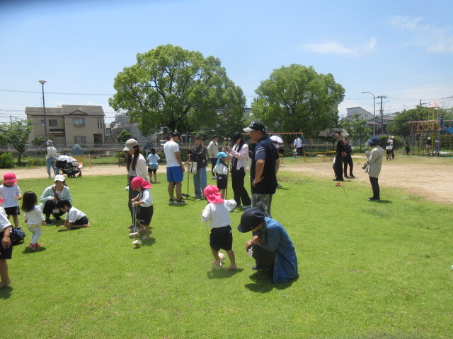 幼児と保護者が竹馬やパカポコに乗って遊んでいる様子