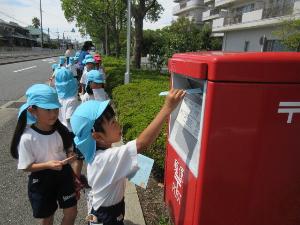 幼児が手紙をポストに投函しているところ