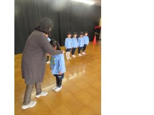 幼児が園長先生からメダルをもらっているところ