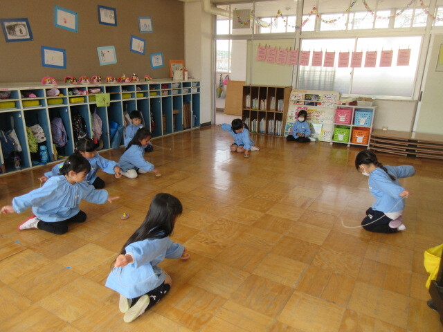 幼児が糸引きこまを回している様子