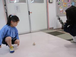 幼児がこま回しをしているところ