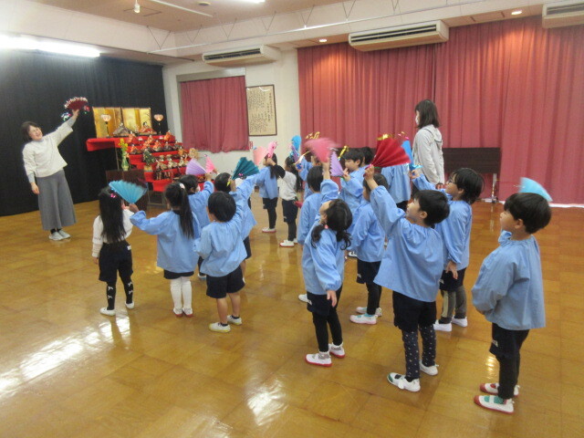 幼児が扇を持ち踊りを踊っている様子
