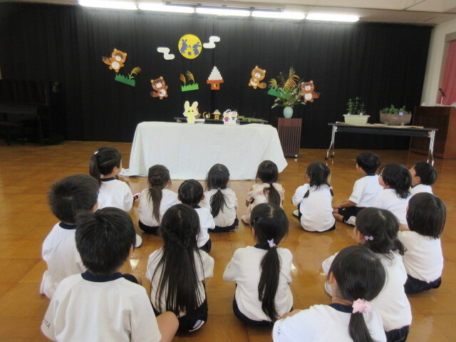 幼児がおつきみうさぎのペープサートを見ている様子