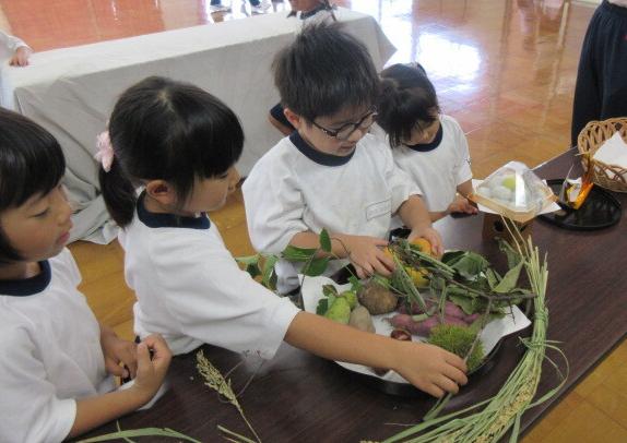幼児がお月見のお供えに触れる様子